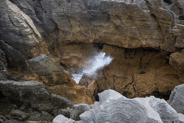 wave breaking between rocks at pancake rocks