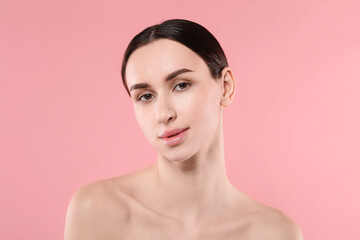 Portrait of beautiful young woman on pink background