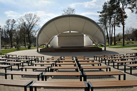 Outdoor Amphitheater In The Park With Benches And A Stage.