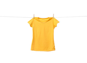 Yellow t-shirt drying on washing line against white background