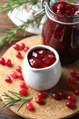 Cranberry sauce, fresh berries and rosemary on table