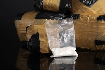 Smuggling and drug trafficking. Packages with narcotics on black mirror surface, closeup