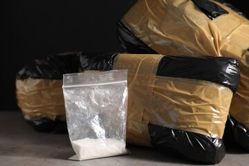 Smuggling and drug trafficking. Packages with narcotics on grey table, closeup