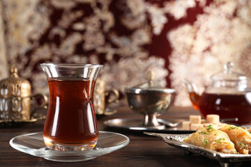 Traditional Turkish tea and sweets served in vintage tea set on wooden table. Space for text