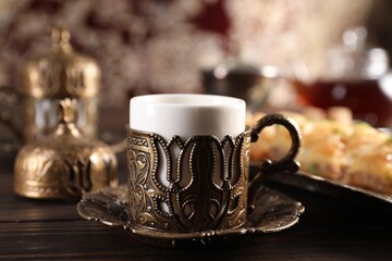 Traditional Turkish tea served in vintage tea set on wooden table, closeup