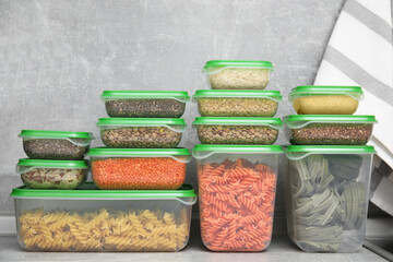 Plastic containers filled with food products on grey table