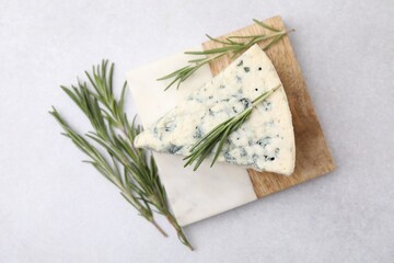 Obraz na płótnie Canvas Tasty blue cheese with rosemary on light table, flat lay