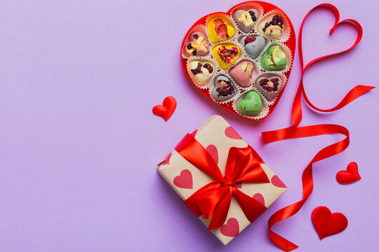 Valentine day composition: sweet candy, with gift boxes with bow and red felt hearts, photo template, background. Top View with copy space