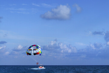 Water Sport of Parasailing. Parasailing water amusement. Holiday at the seaside.  Flying on a parachute behind a boat on a summer holiday. Active and extreme form of relaxation. Sea 
boat
