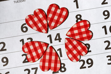 14 february on a calendar sheet and hearts, closeup