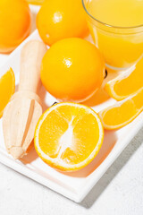 fresh oranges on a wooden tray, closeup vertical