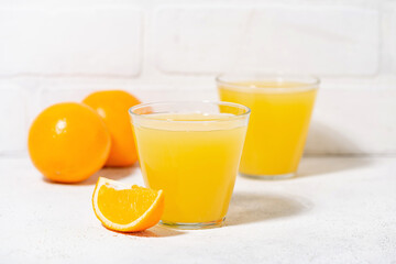glasses of freshly squeezed orange juice on a white table