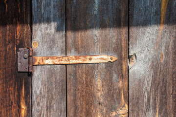 Rusty door hinges on the door of the barn