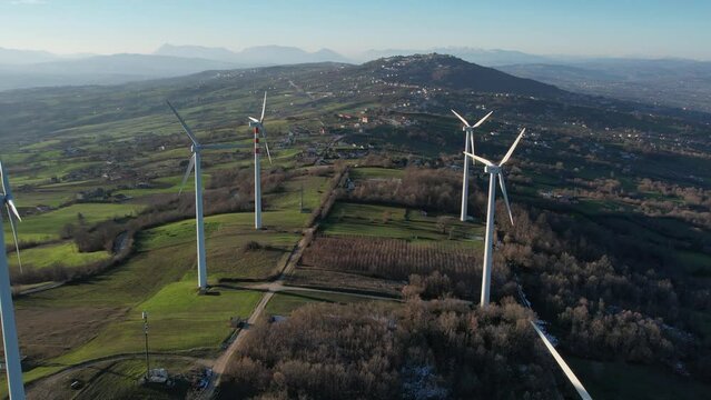 Drone. Pale eoliche su collina verde. Movimento in avvicinamento. Italia, Campania, Avellino.
