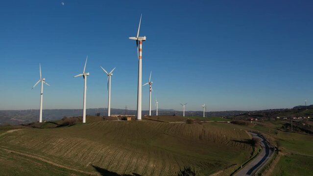Drone. Pale eoliche su collina verde. movimento in avvicinamento. Italia, Campania, Avellino.