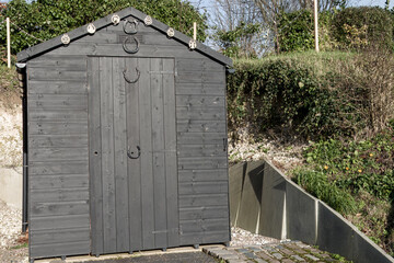 black wooden shed with horse shoes and brasses