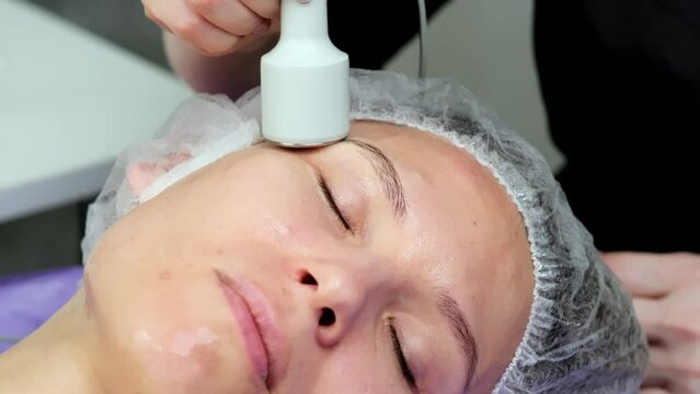 Hardware procedure in cosmetology. Close-up. Non-surgical facial skin lifting in a beauty clinic. A cosmetologist, a cosmetologist, moves a manipulator over the face. microcurrent treatment.