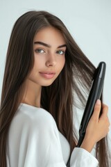 Fototapeta premium Hair care, hair straightener and woman's image. Salon and beauty treatment. Healthy hair flat iron tool by white background