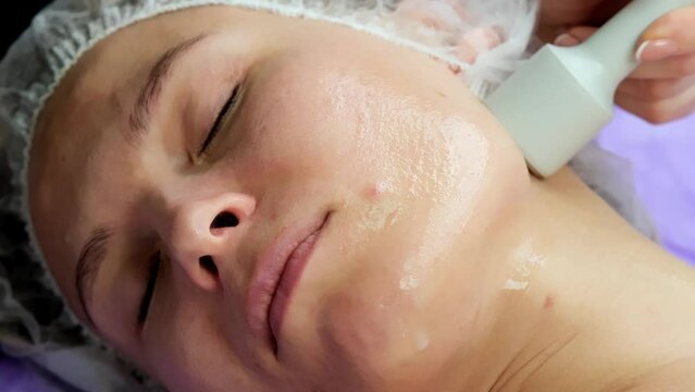 Hardware procedure in cosmetology. Close-up. Non-surgical facial skin lifting in a beauty clinic. A cosmetologist, a cosmetologist, moves a manipulator over the face. microcurrent treatment.