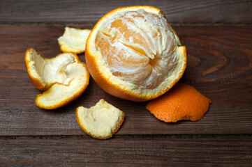Close-up texture of an peeled ripe sweet tangerine fruit on a wooden board.