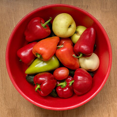 Fresh vegetables in a heap in a bowl, home grown sweet red, yellow, green peppers, apple, sauce