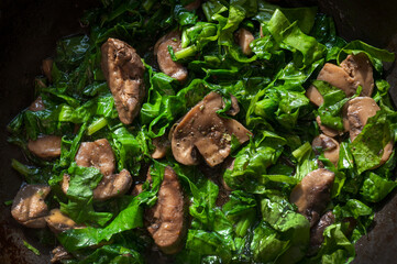 Healthy vegetarian food, spinach and stewed mushrooms close-up, spinach and mushrooms