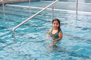 Girl entering the swimming pool to bathe with wet hair and body