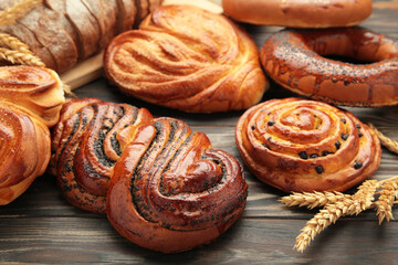 Bakery - various kinds of breadstuff. Bread rolls, bagel, sweet bun on brown background.