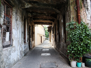 Fototapeta na wymiar an alley with a small tunnel leading to the street. surabaya, indonesia - 4 january 2024