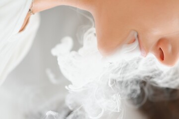 A woman smokes an electronic cigarette