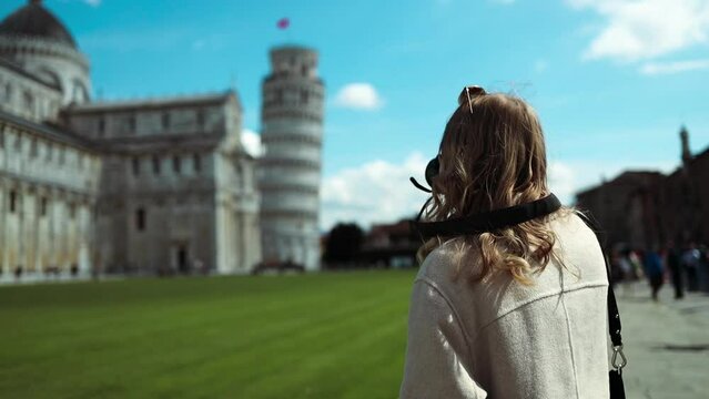 Portrait of Happy photographer lady taking photo holding camera near face and standing near Pisa, town in Italy. Professional Creative Professions Concept. High quality FullHD footage