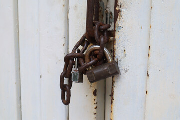 close up of the padlock and chain locking the door. surabaya, indonesia - 4 january 2024