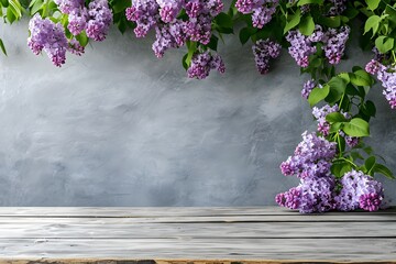 an empty light wooden table top with flowering branches of delicate purple lilac, on a light gray background,a place for text, a product presentation design concept, a layout