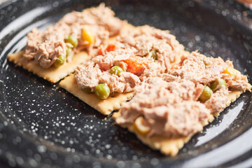 Crackers with tuna salad and mayonnaise