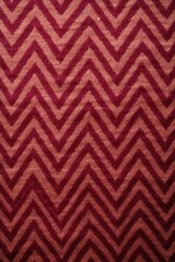 Maroon zig-zag wave pattern carpet texture background 