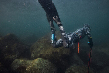 Freediver exploring underwater rocks