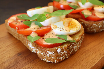 Closeup of Multi Grains Toast Open Faced Sandwich Topped with Hard Boiled Egg and Tomato