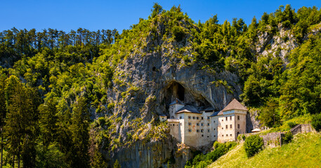 Panorama of Predjama castle built in a cave in Slovenia. Popular tourist attraction and historic...