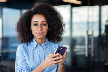 Fototapeta premium A television presenter is seen gracefully holding an electric blue mobile phone, a portable communications device, during an event.