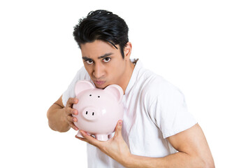 Young greedy stingy man holding piggy bank isolated on white background