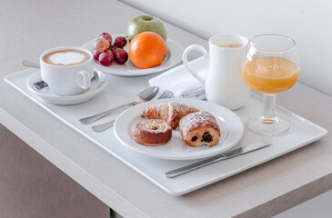 A continental breakfast setup with pastries, coffee, and fresh fruit