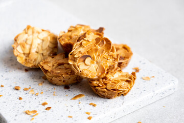 Nut almond flakes candy bars on marble board on white background. Healthy candies and cookie. Dieting high protein energy bar. Alternative dessert.
