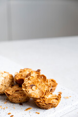 Nut almond flakes candy bars on marble board on white background. Healthy candies and cookie. Dieting high protein energy bar. Alternative dessert.