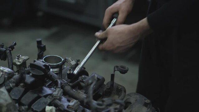 Repairing an internal combustion engine in a car service center. Hands of car mechanic working in auto repair service.