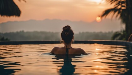 Fototapeta premium Portrait of woman in infinity pool in Bali, sunset view