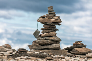 A stack of pebbles on a beach, Cape Enrage Nature Reserve, Bay of Fundy, New Brunswick, Canada. Tourists leave their mark by building these stone cairns.