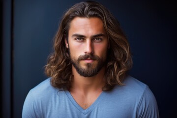 Fototapeta premium A photo of a man with long hair and a full beard, looking directly into the camera.