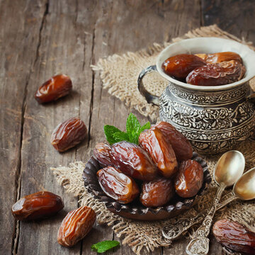 Dates are an indispensable food at the dinner table during Ramadan. A plate of dates and cups of tea on the dining table. Ramadan concept