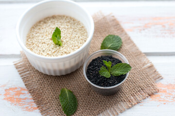 sesame seeds in a bowl on a wooden background. Seasoning for cooking