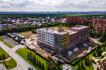 the construction site of an apartment building in the summer from a height